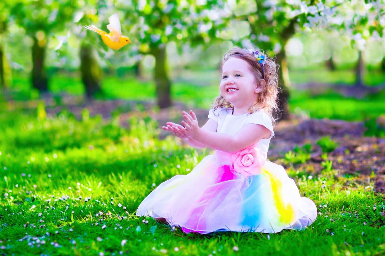 little girl in fairy costume feeding a bird
